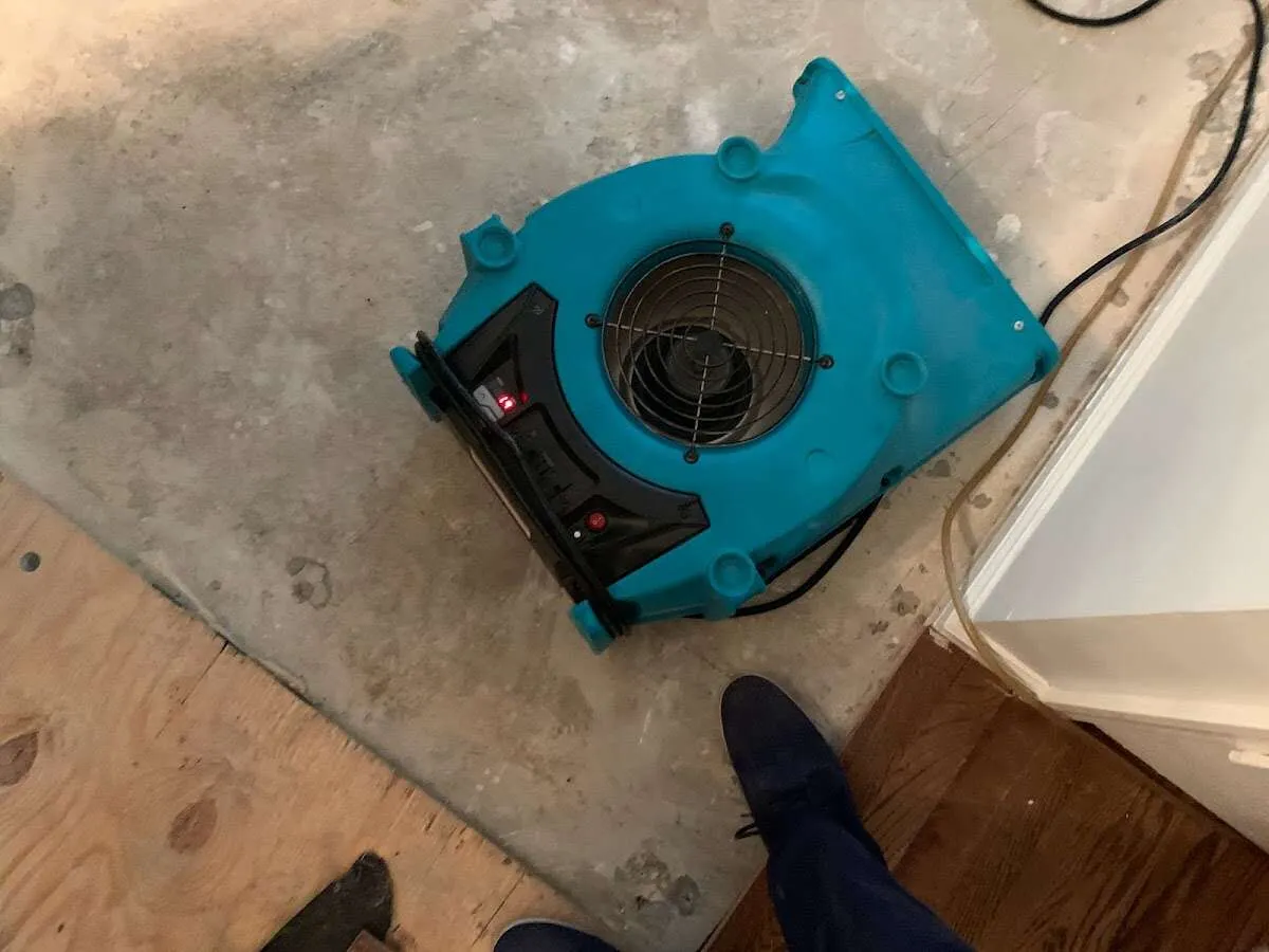 Air mover drying subfloor during Commercial Water Damage Restoration in Shiprock